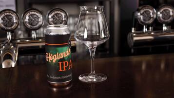 Een blik Höglands IPA en een leeg glas op een bargedeelte.