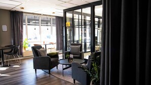 Un espacio de oficina moderno con un amplio ventanal, una mesa redonda y varias sillas.