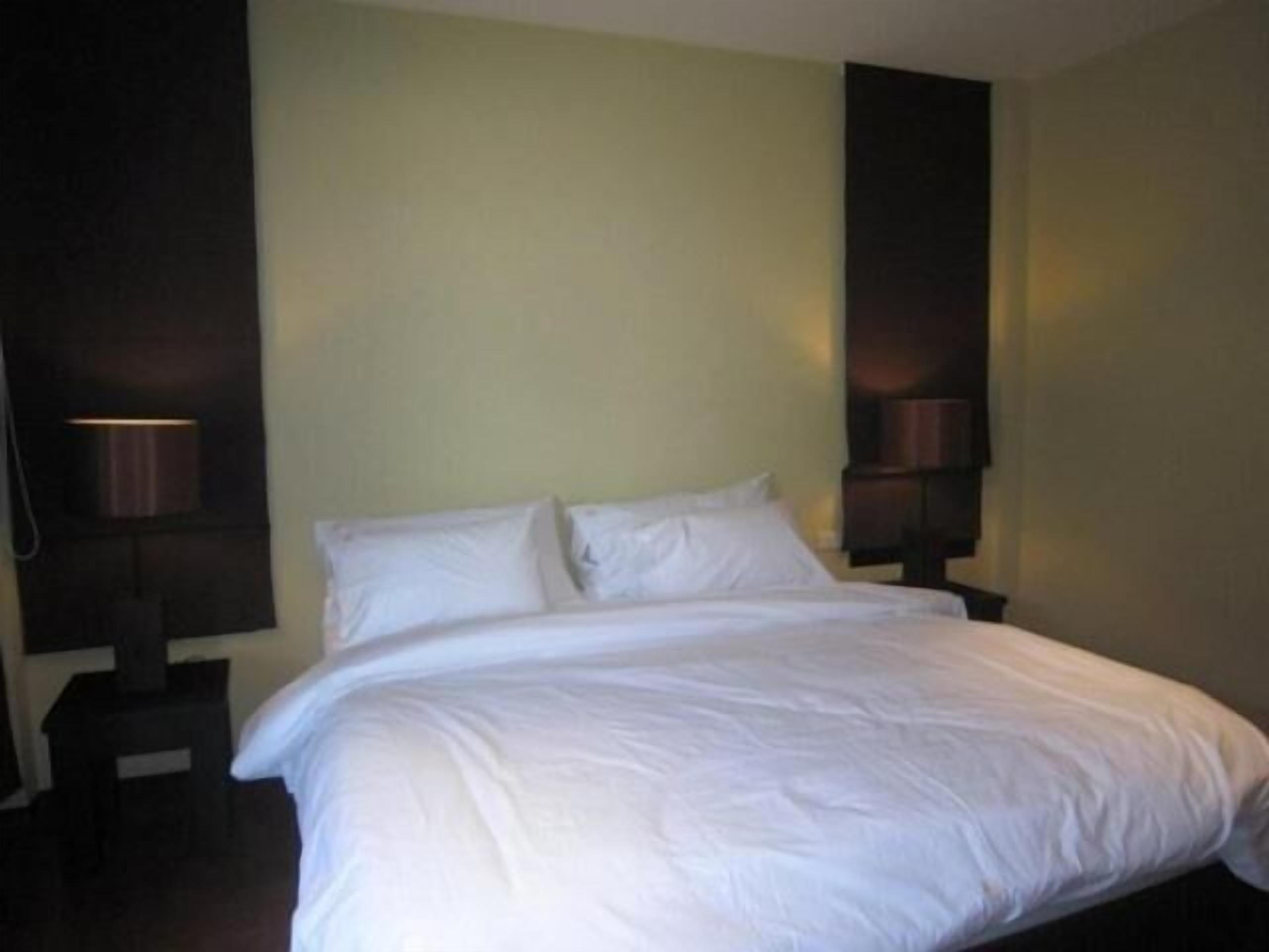 A neatly made bed in a room with a simple, clean design.