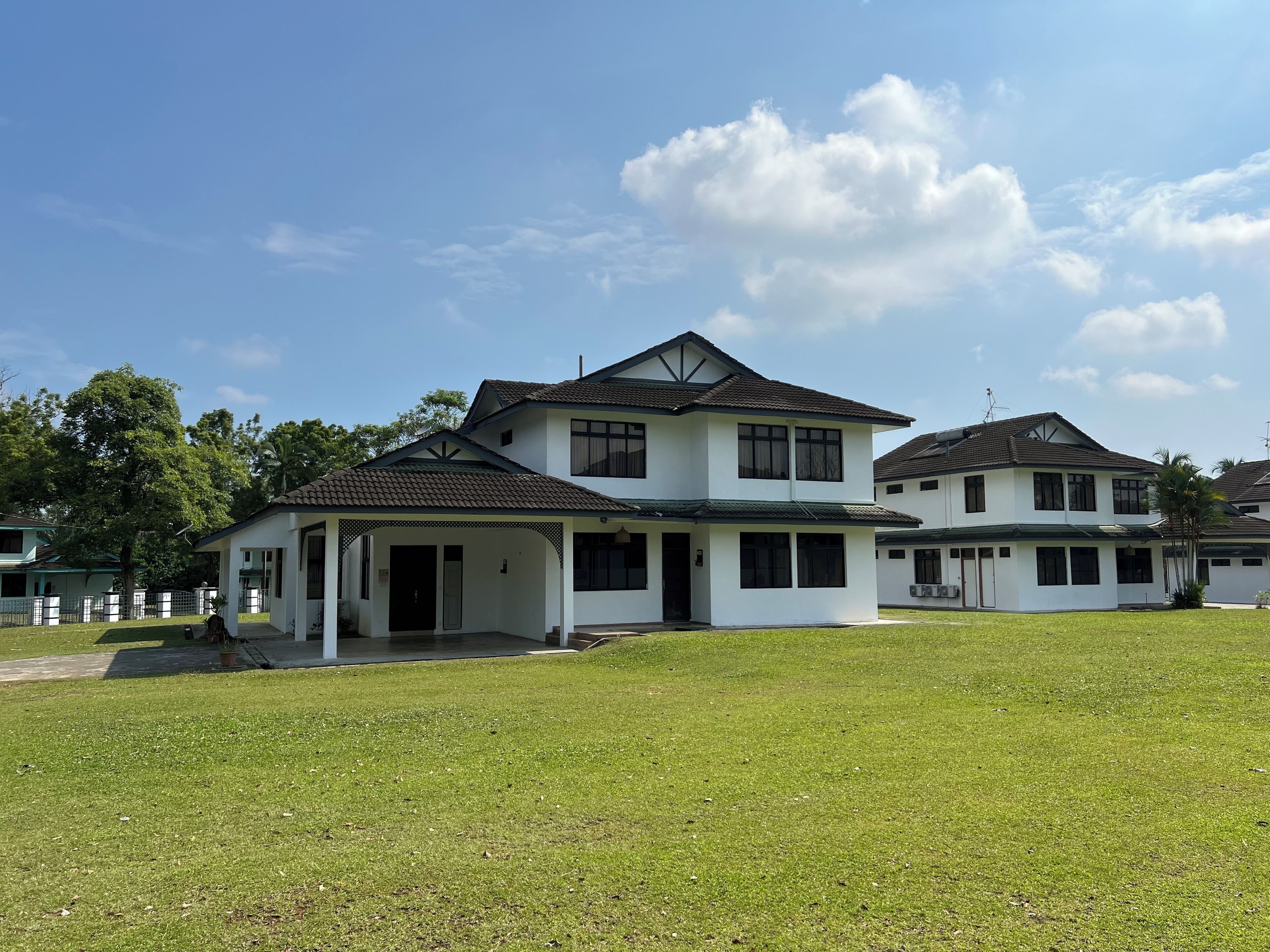 A two-story house with a covered porch and a well-maintained lawn.
