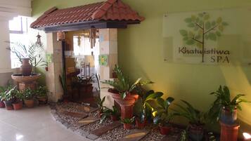 A spa entrance with a tiled roof, potted plants, and a sign reading "Khatuistiwa SPA".