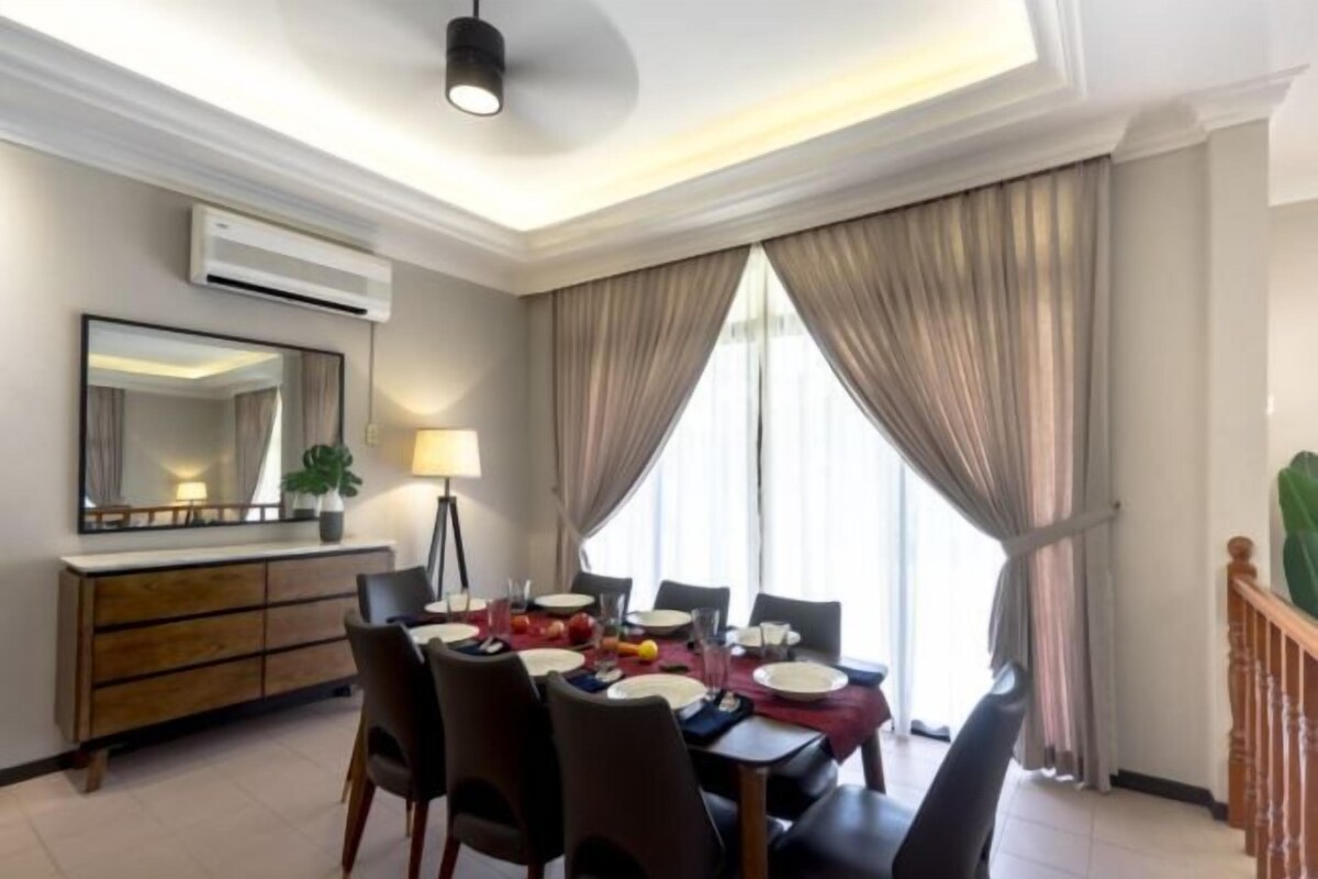 A dining area with a table set for four, a mirror above the table, and a plant on the wall.