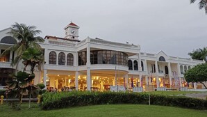 A large, multi-story hotel with a central courtyard, featuring a clock tower and multiple dining areas. - Tanjong Puteri Golf Resort - Malaysia (Pasir Gudang)
