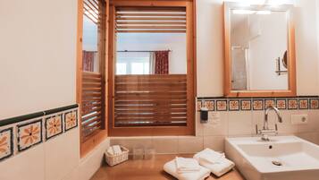 A bathroom with a wooden window, a sink, and a mirror.