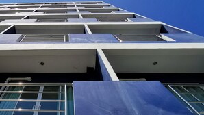 A multi-story building with a modern architectural design, featuring large windows and balconies.
