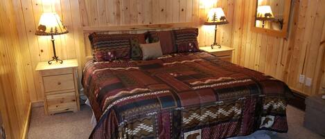 Una camera da letto con pannelli in legno, un letto grande, due comodini e due lampade a parete.