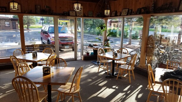 A restaurant with wooden interior, large windows, and outdoor seating. - The Willard Munger Inn (Duluth)