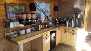 A wooden kitchen with a built-in dishwasher, a coffee machine, and various kitchen appliances. - The Willard Munger Inn (Duluth)