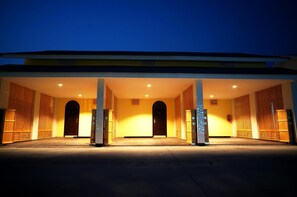 A hotel entrance with a covered walkway, wooden doors, and a yellow facade. - Roses Hua Hin Hotel (Hua Hin)