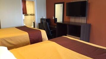 A hotel room with two beds, a desk, a chair, a television, and a mirror.
