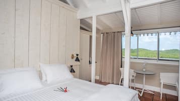 Un dormitorio con cama, escritorio y vistas al exterior.
