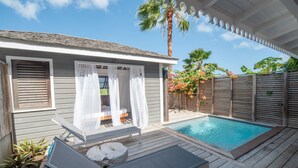A poolside area with a covered seating area, a small pool, and a wooden deck. - Hôtel Plein Soleil (Le Francois)