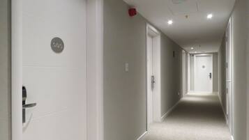 A corridor with white doors, each marked with a number.
