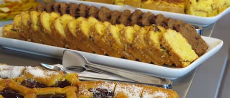 A buffet with various baked goods including pies, cakes, and pastries.