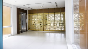 Un pasillo amplio con un separador decorativo, una puerta y un ventanal.