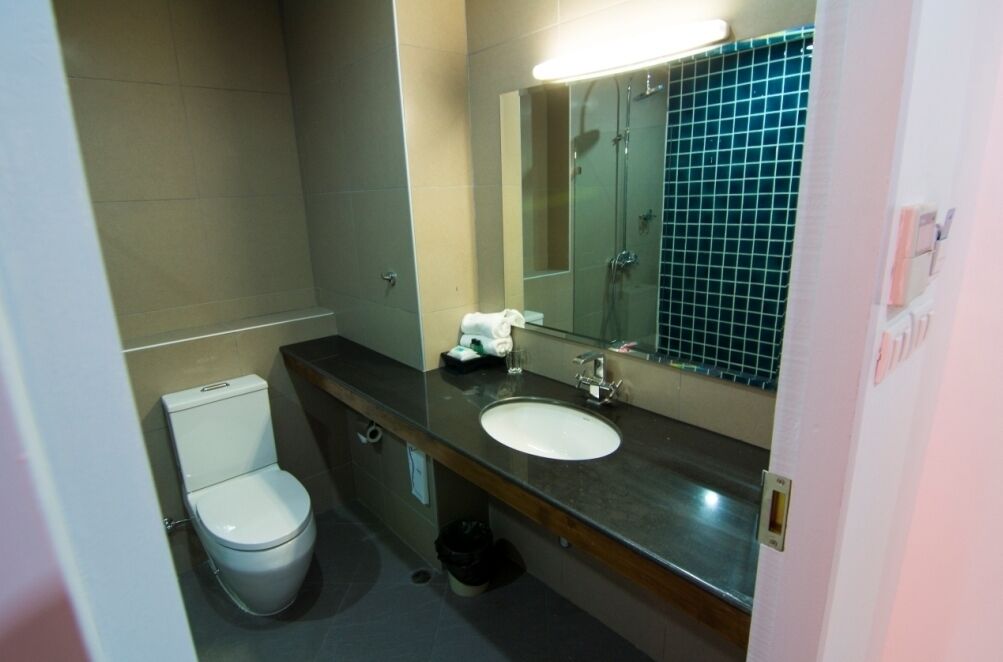 Une petite salle de bain avec des toilettes, un lavabo et un miroir.