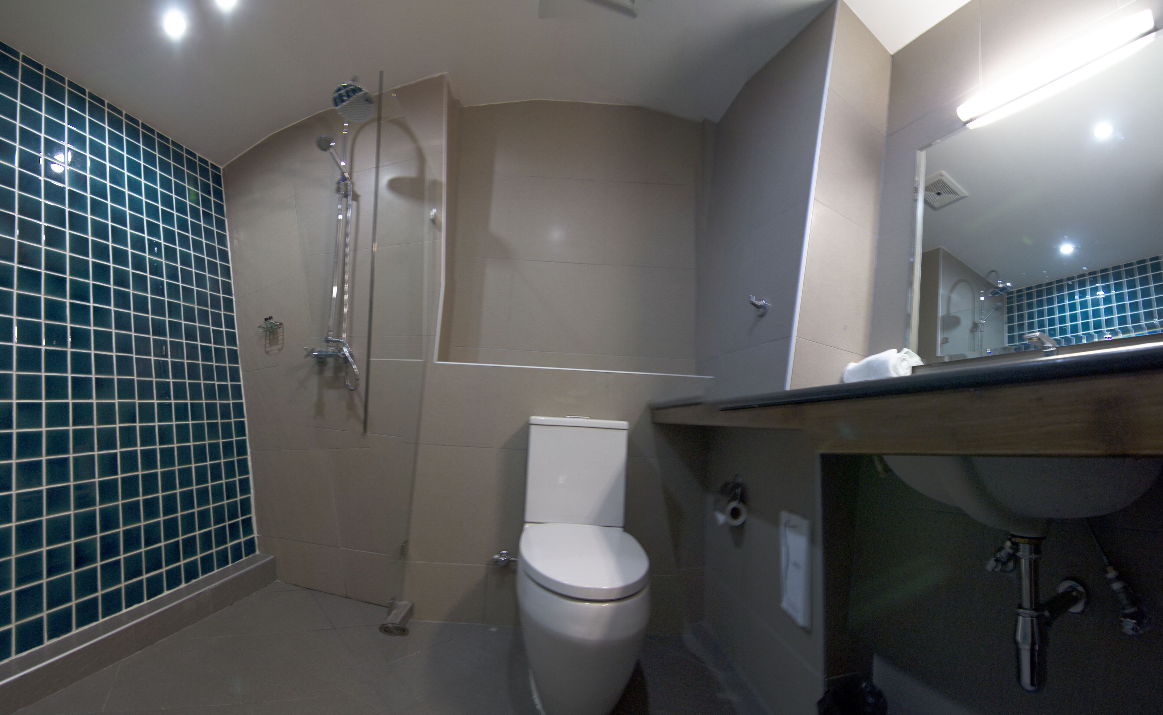 A bathroom with a shower, toilet, and sink.