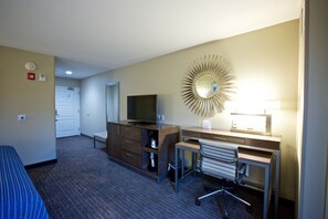 A hotel room with a bed, a desk with a chair, a television, a mirror, and a lamp. - Holiday Inn Express Fargo SW - I-94 Medical Center by IHG (Fargo)