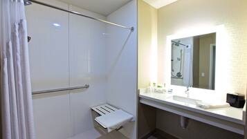 A modern bathroom with a shower, a towel rack, a sink, and a mirror.