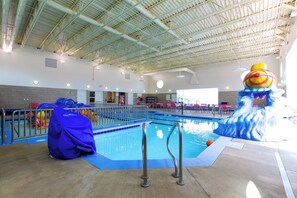 An indoor swimming pool with a high ceiling, clear pool area, and a lifeguard station. - Holiday Inn Express Fargo SW - I-94 Medical Center by IHG (Fargo)