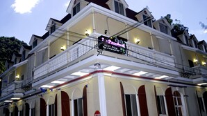 A hotel with a balcony, multiple windows, and a stop sign. - Le Paradis S. Hotel (Cap-Haitien)