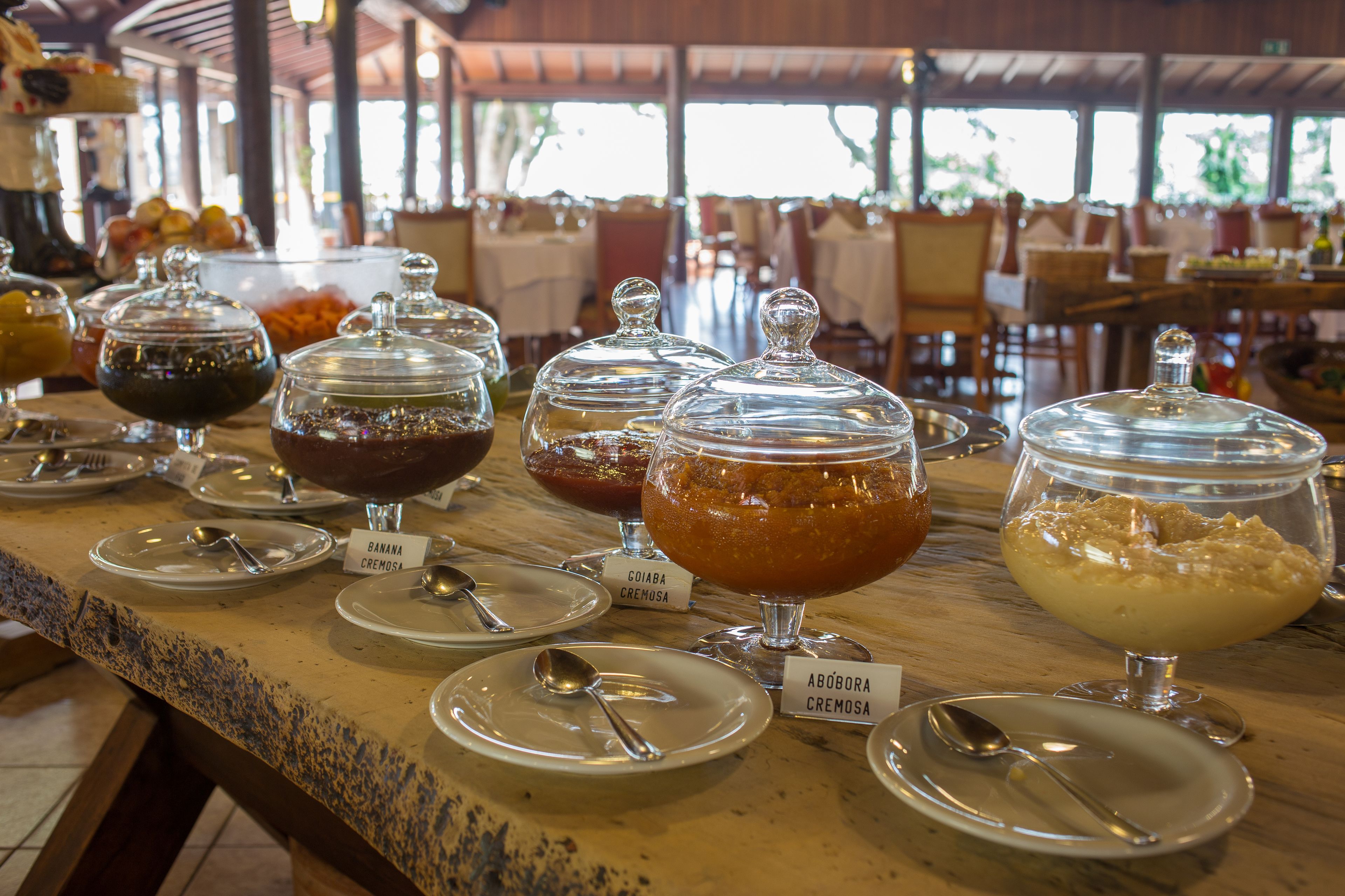 A buffet with various food items in glass containers, each labeled with the dish name.