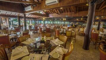 Un restaurante espacioso con interiores de madera, varias mesas y sillas.