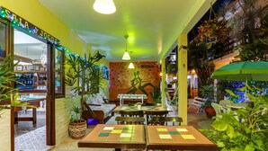 Ein Restaurant mit Innenbereich, Wandgemälde und Topfpflanzen.