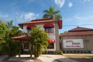 Un edificio de dos plantas con techo de tejas rojas, un letrero que dice