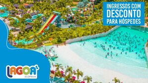 Un resort con una piscina grande, toboganes acuáticos y zona de playa.