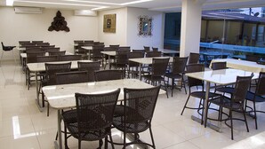 A spacious dining area with multiple tables and chairs, air conditioning units, and decorative wall art. - Hotel Morada das Aguas (Caldas Novas)