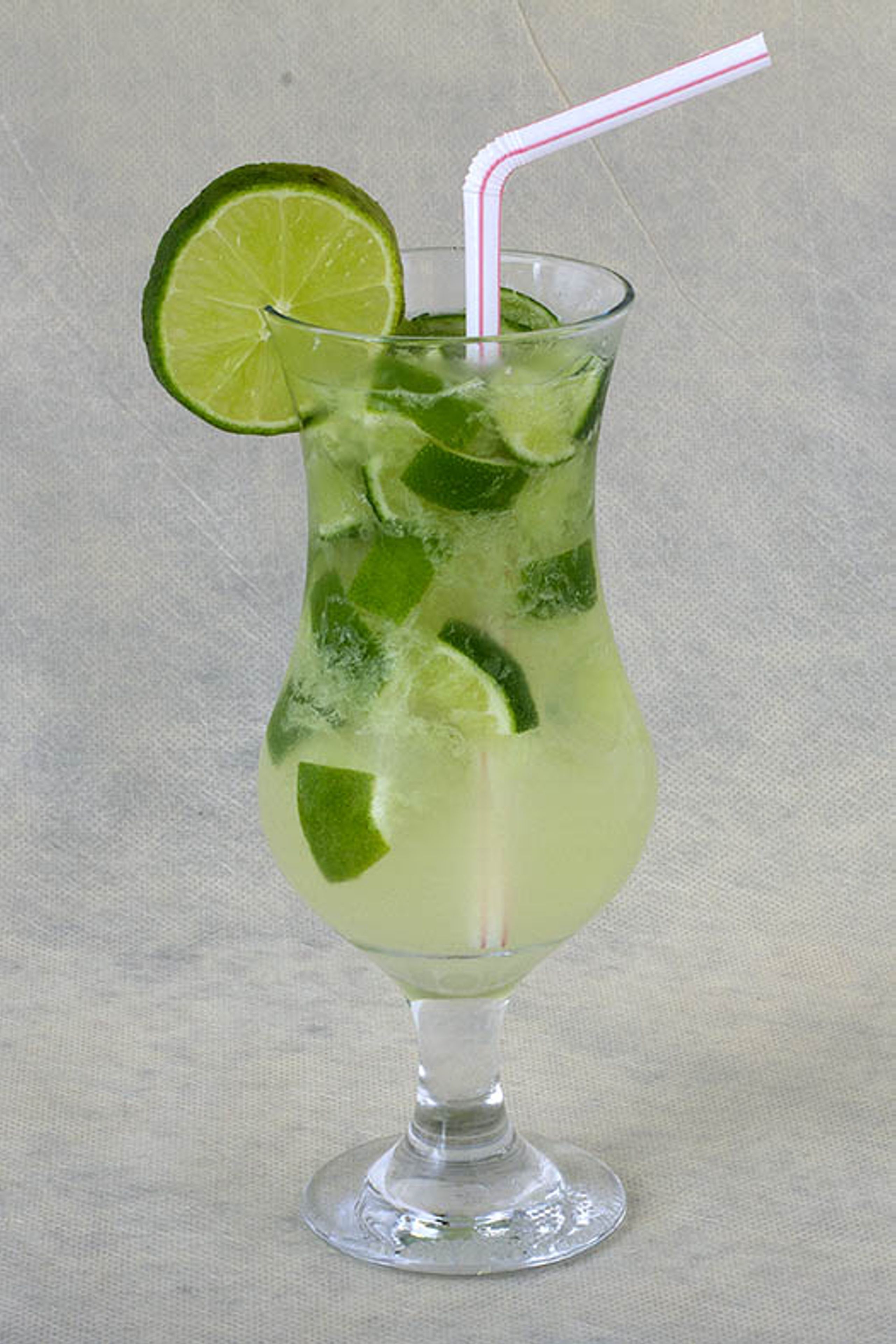 Ein Glas mit Limettenscheibe und Trinkhalm.
