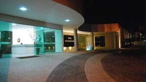 A modern building with a curved facade, large glass windows, and a well-lit entrance area. - Hotel Morada do Sol (Caldas Novas)