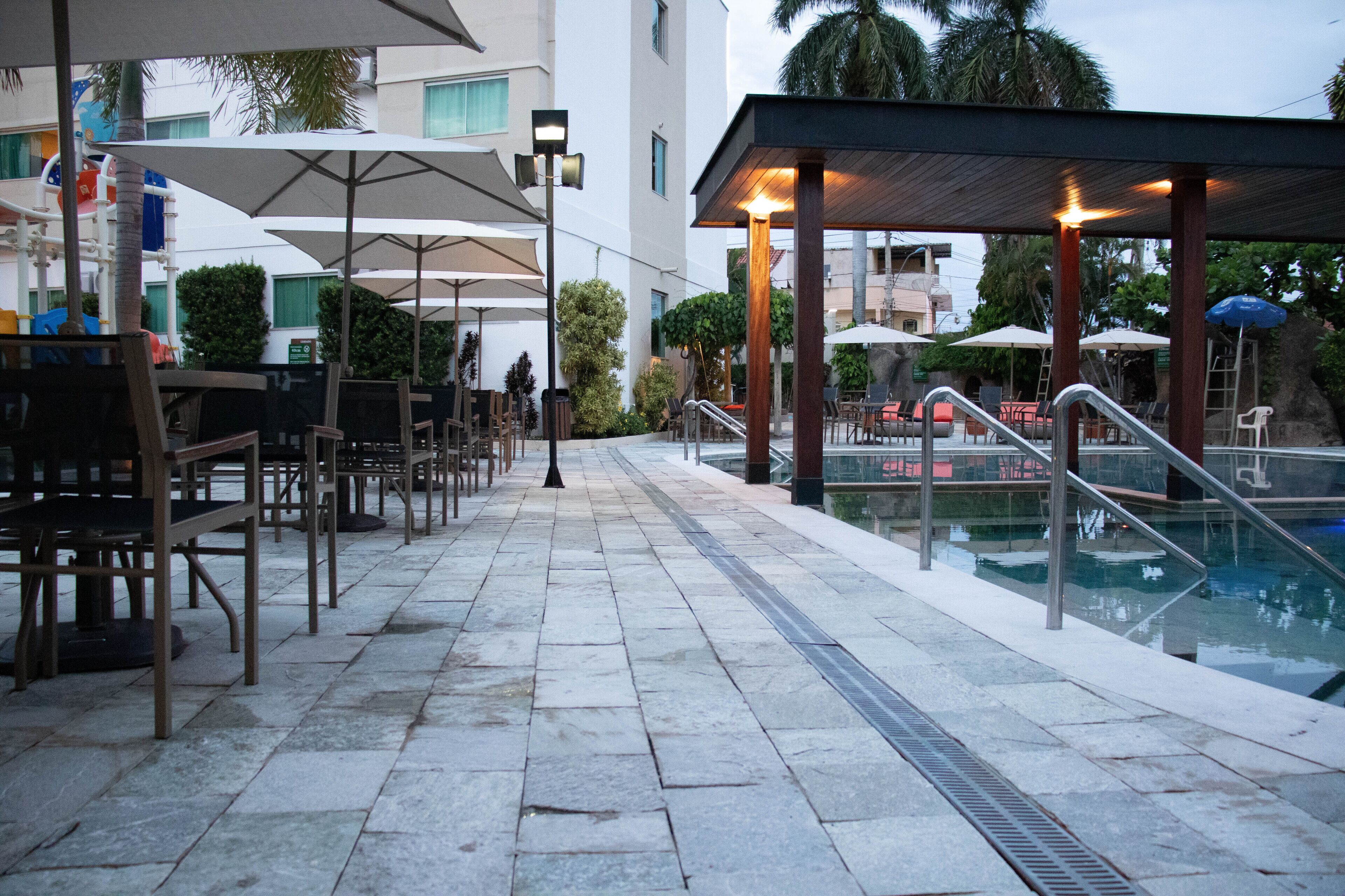 A poolside area with outdoor seating and umbrellas.