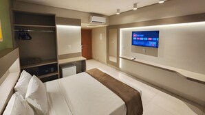 A hotel room with a bed, a wardrobe, a desk, and a TV mounted on the wall. - Hotel Morada do Sol (Caldas Novas)