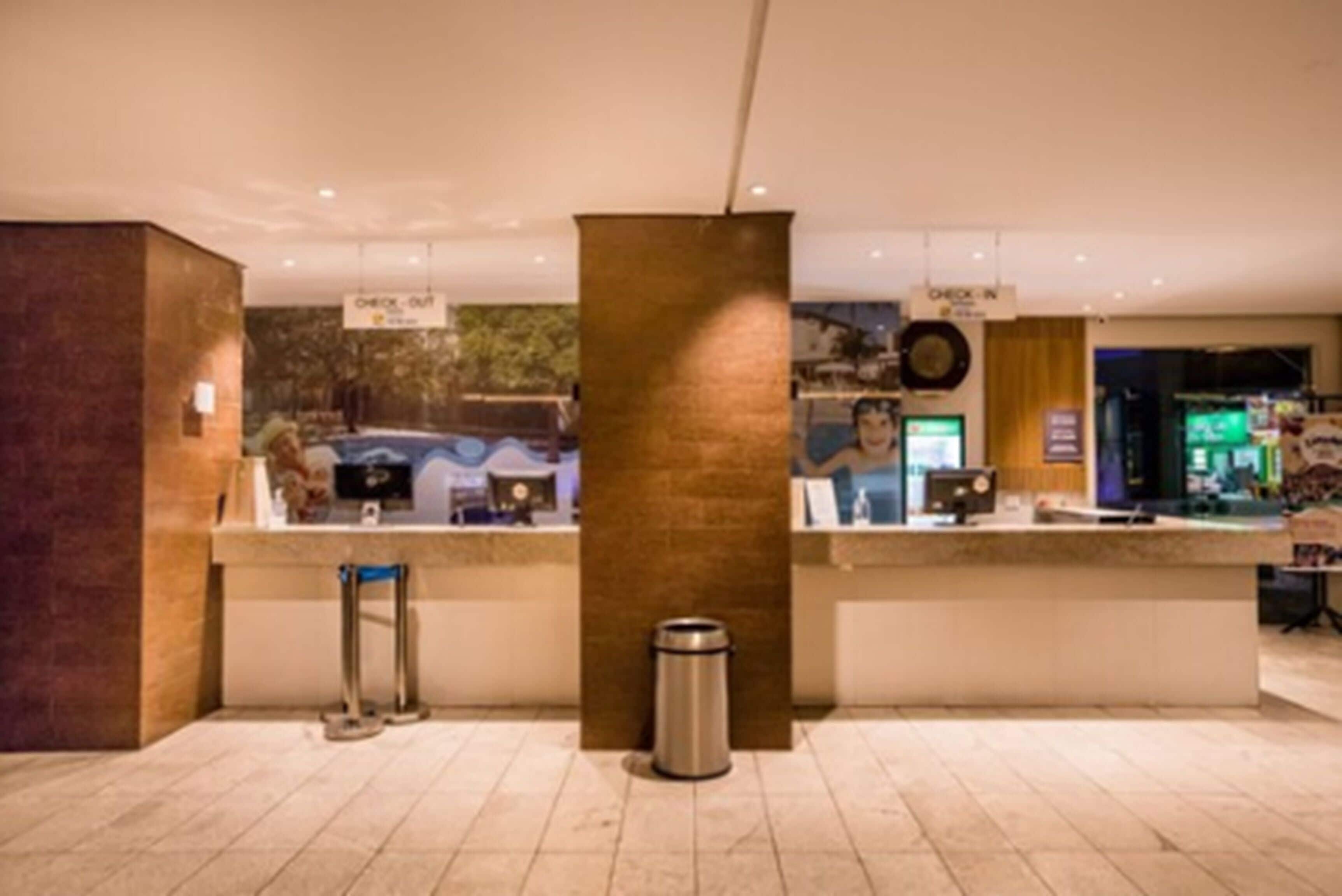 A reception area with a counter, a trash bin, and a sign indicating 'Check-in'.