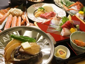 Ett urval av olika fisk- och skaldjursrätter på ett bord, inklusive räkor, fisk och andra sorters skaldjur.