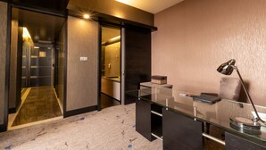 A modern hotel room with a glass desk, a lamp, and a view of the hallway. - New World Suites (Bintulu)