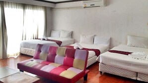 A hotel room with two beds, a sofa, and a wooden table. - The XP Bangkok (Bangkok)