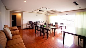 A spacious living area with a dining table, chairs, a sofa, and a kitchen area with a refrigerator and microwave. - The XP Bangkok (Bangkok)