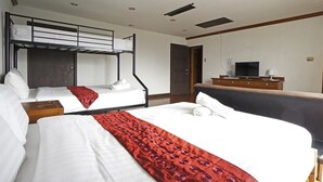 A hotel room with a bunk bed, a single bed, a desk with a TV, and a wardrobe. - The XP Bangkok (Bangkok)