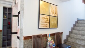 A lobby with a staircase, a reception desk, and a seating area with chairs and a table. - The XP Bangkok (Bangkok)
