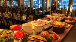 Una mesa de buffet con frutas, verduras y quesos variados.