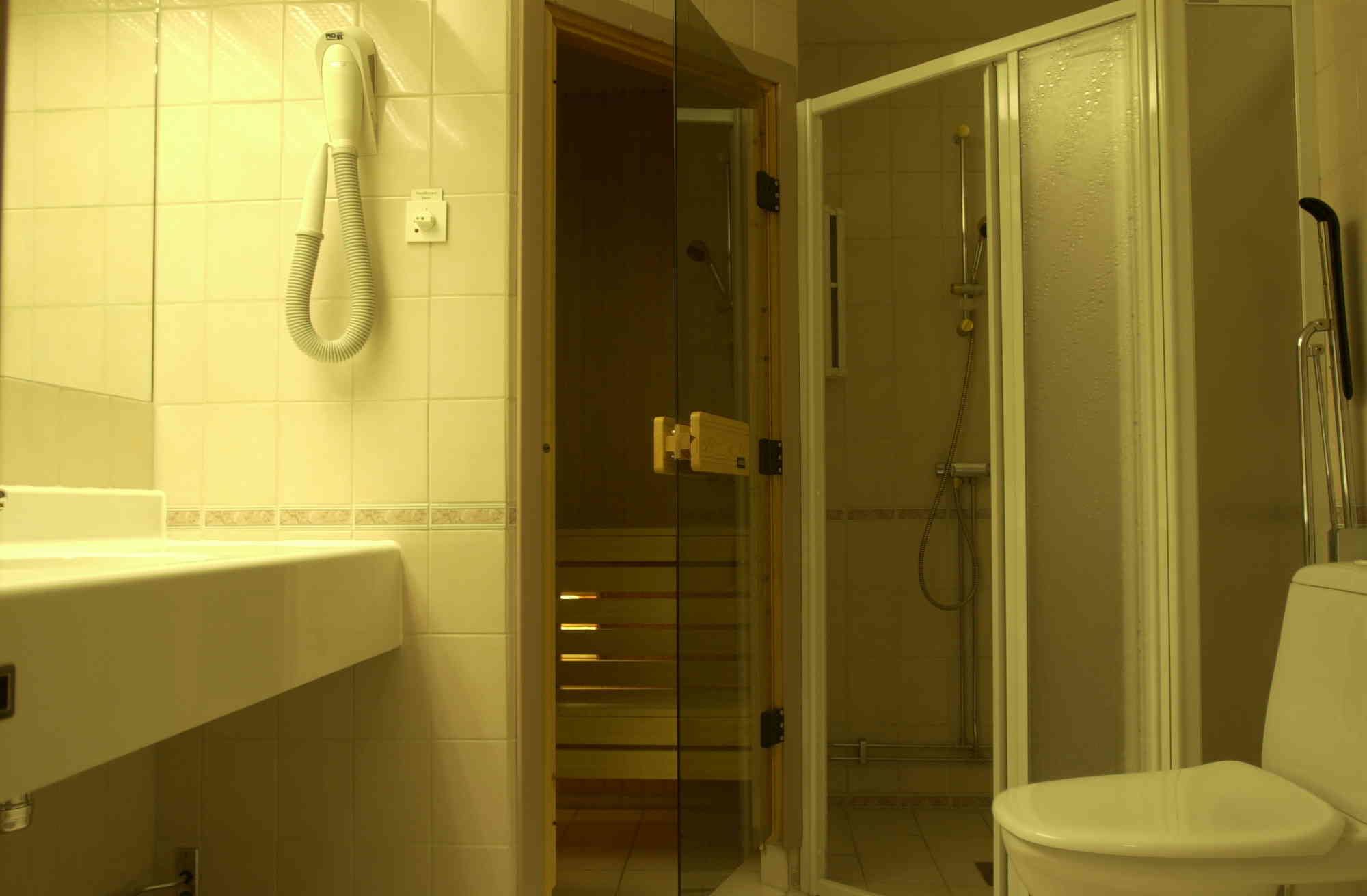 A bathroom with a shower, toilet, and sink.