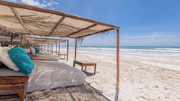 On the beach, white sand, sun loungers, beach umbrellas
