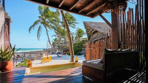 A wooden deck with a thatched-roof structure, a small pool, and a view of the beach and ocean. - La Zebra Tulum - a Small Luxury Hotel (Tulum)