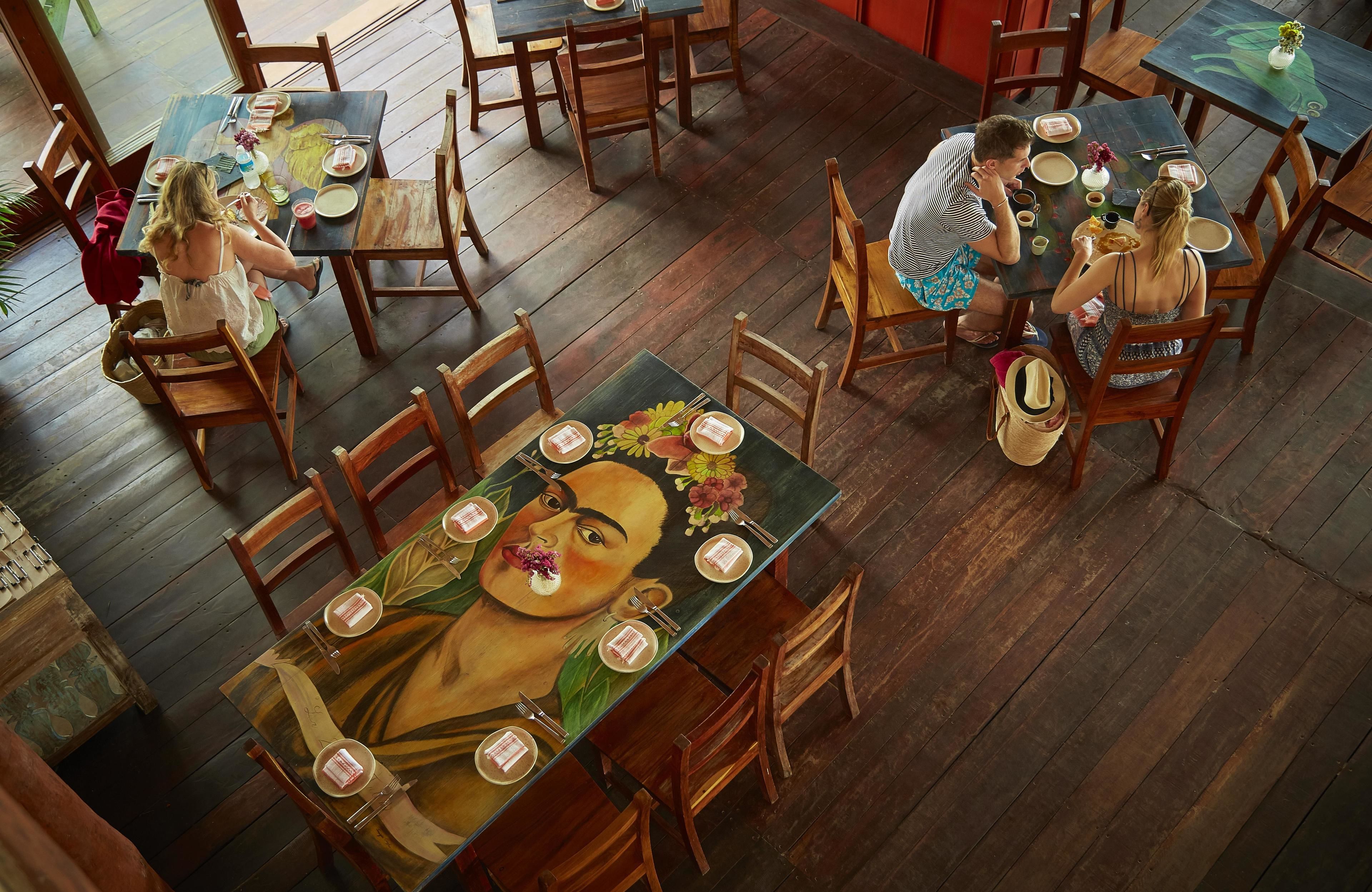 Un restaurant doté de planchers et de tables en bois, aménagé pour accueillir les clients.
