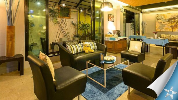 Una sala de estar moderna con sofás de cuero, un separador de vidrio y una zona de comedor con mantel azul.