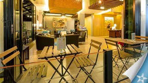 Un moderno vestíbulo de hotel con mobiliario de madera, una recepción y una escalera.