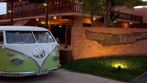 Una furgoneta Volkswagen antigua estacionada frente a un edificio con un letrero de madera que dice "Oceano Bonito".